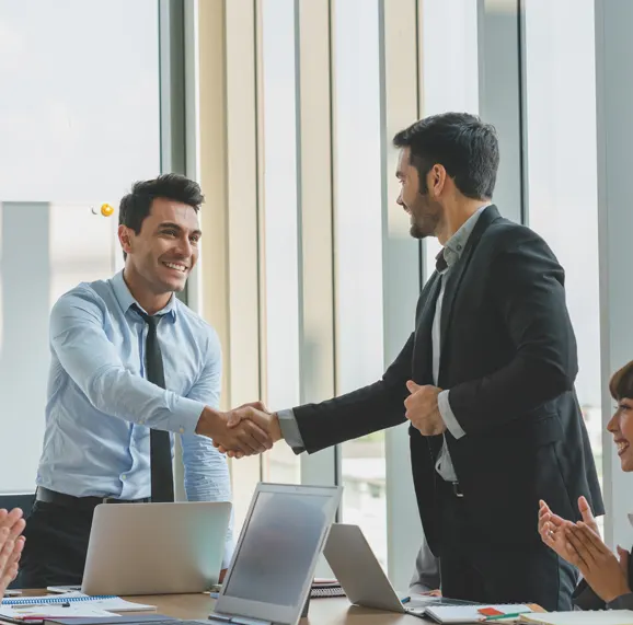A lender and a business owner shaking hands after closing a deal